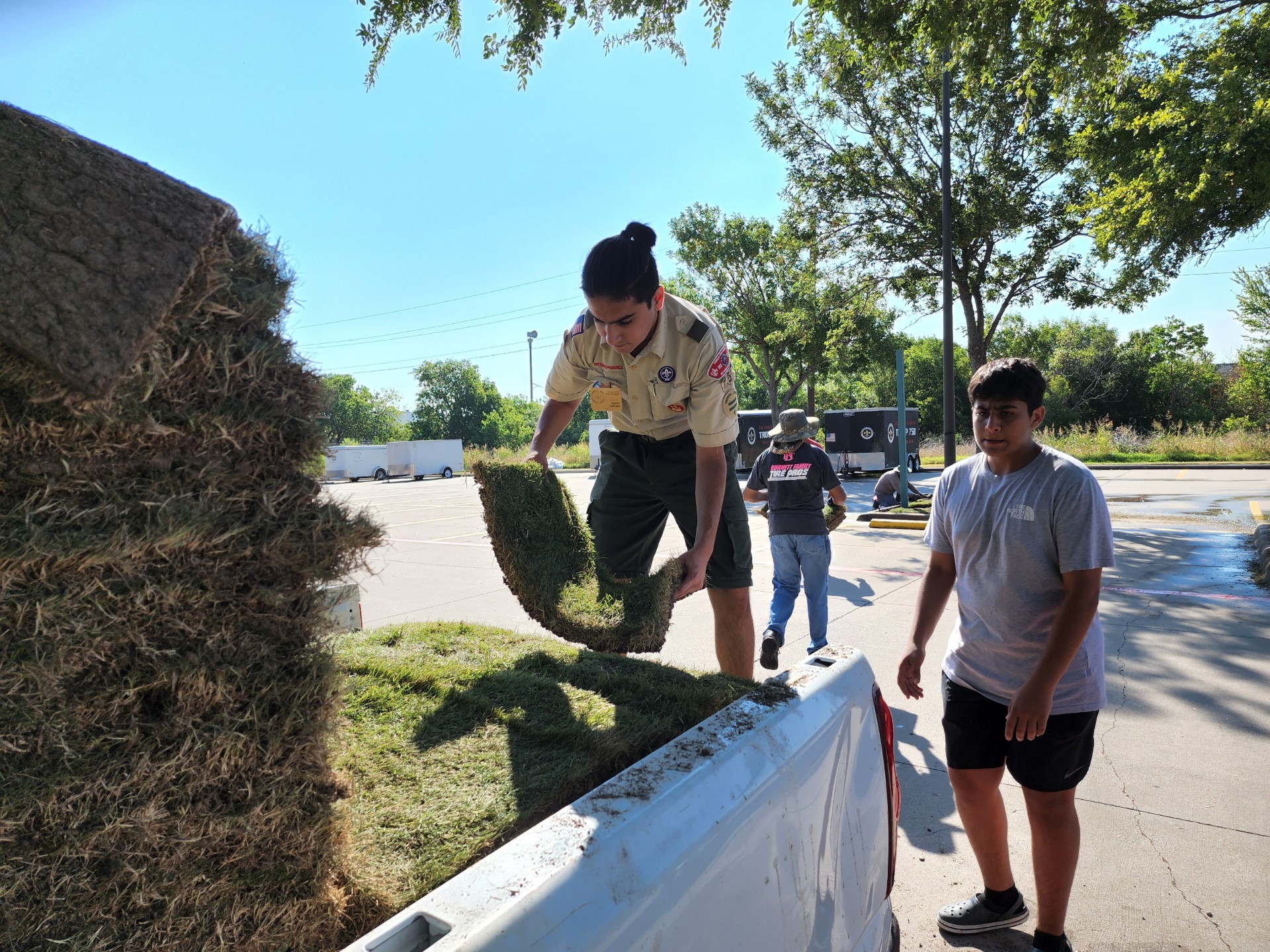 Sahir Lakhani and volunteers unloading rolls of grass for the mosque beautification project